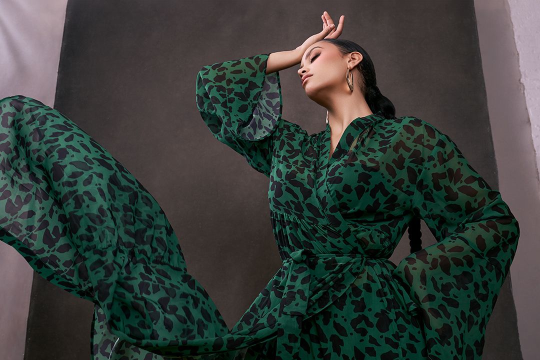 High fashion female portrait wearing a sheer green dress with it blowing in the wind