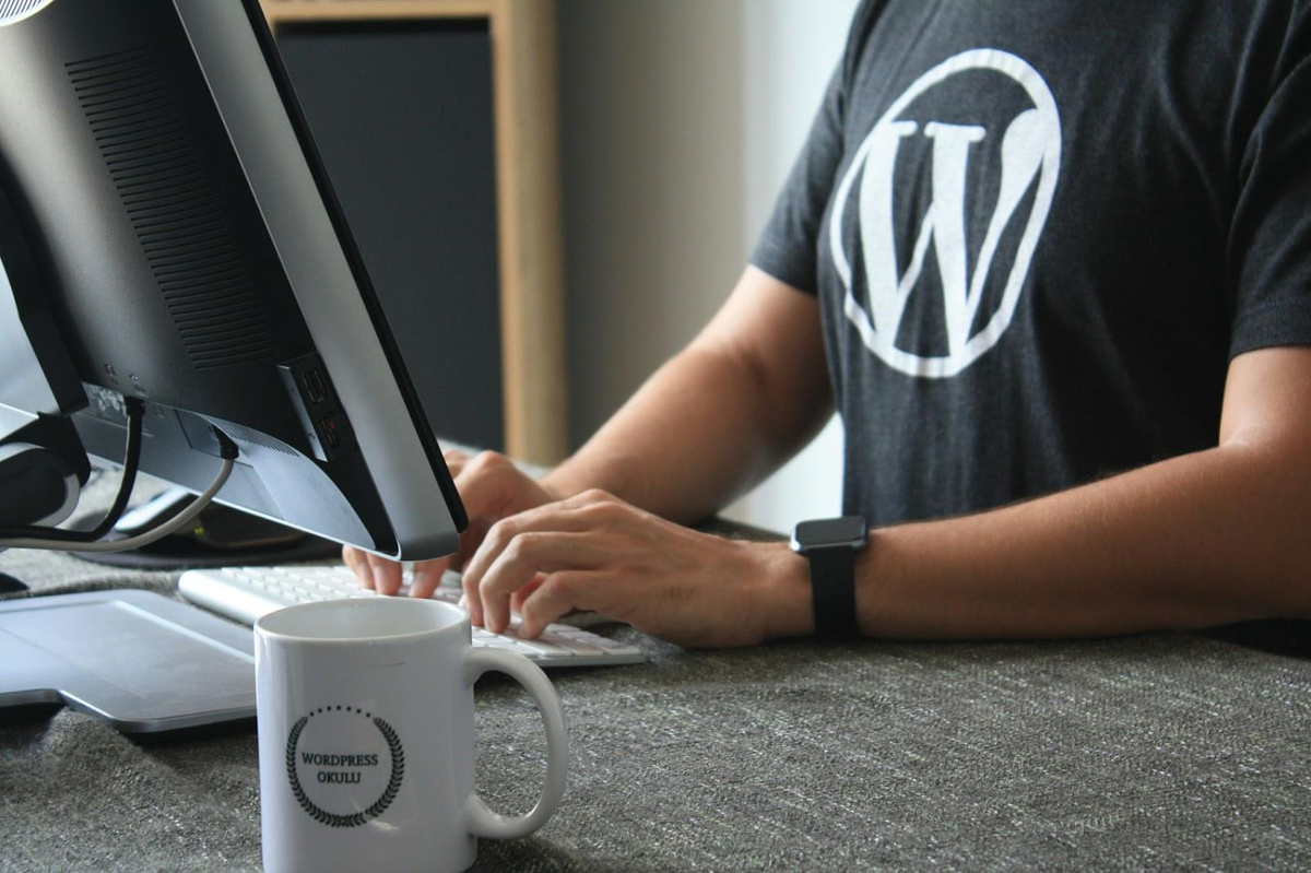 Man with wordpress logo working in computer
