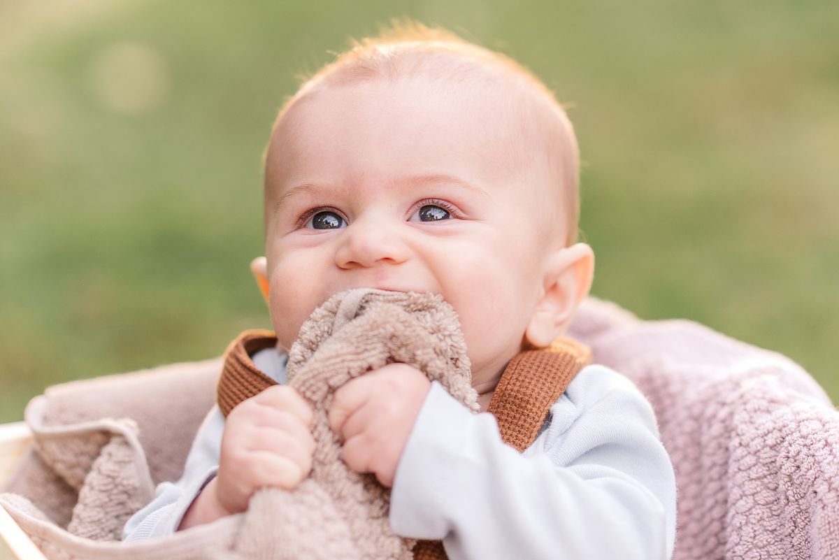 Baby chewing on a soft towel and smiling