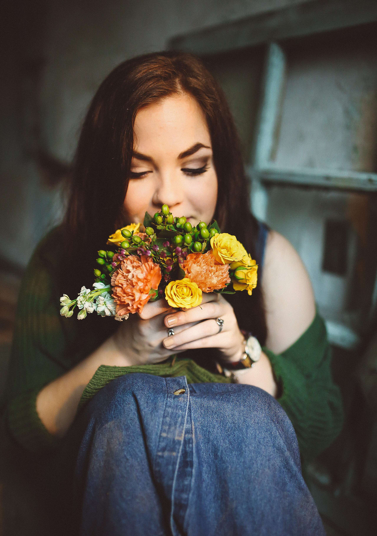 Young woman holding brightly colored flowers.