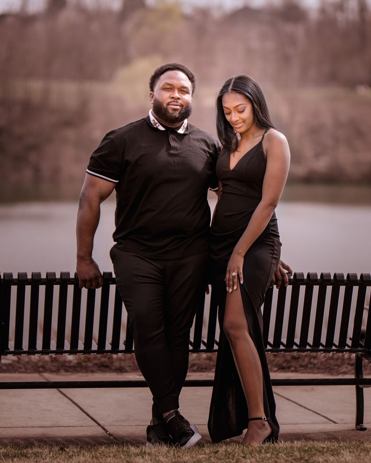 Engagement photos for valentine surprise proposal, bride and groom leaning against a bench and the bride is showing off her engagement ring.