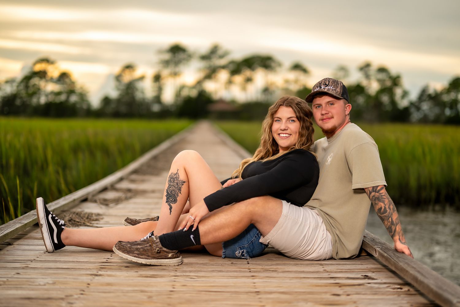 Couple posing on a wooden bridge at Hunting Island State Park, South Carolina, during an outdoor engagement photography session.