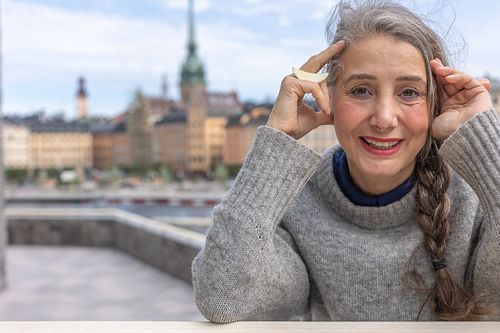 Närbild för personal branding i Stockholm – person i grå tröja med stadssiluett i bakgrunden.