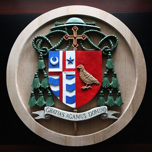 painted coat of arms on unstained oak medallion with second layer ring