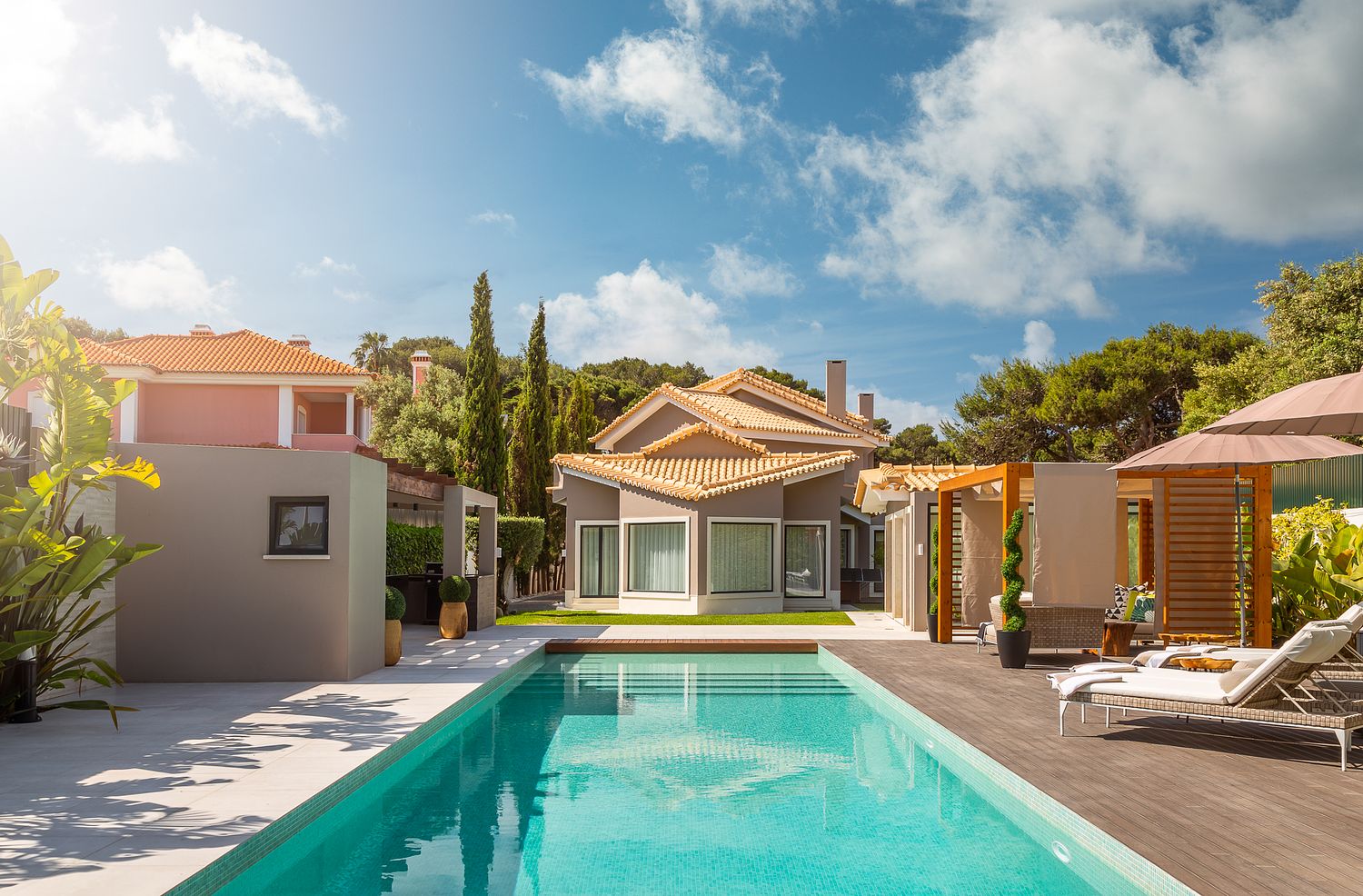 Jardim e área de lazer com piscina em moradia decorada por Raquel Lopes Design, projeto de exteriores e paisagismo fotografado por Pedro Brás Photography — fotografia profissional de design de exteriores e espaços residenciais de luxo em Portugal.