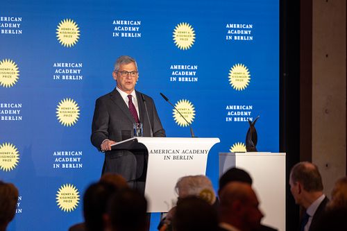 Daniel Benjamin delivering a speech on stage at the Axica Convention Centre.