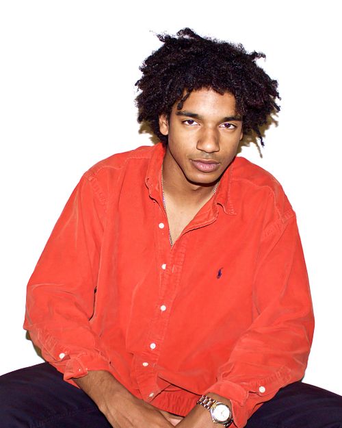 Portrait of a black man in an orange shirt with white background
