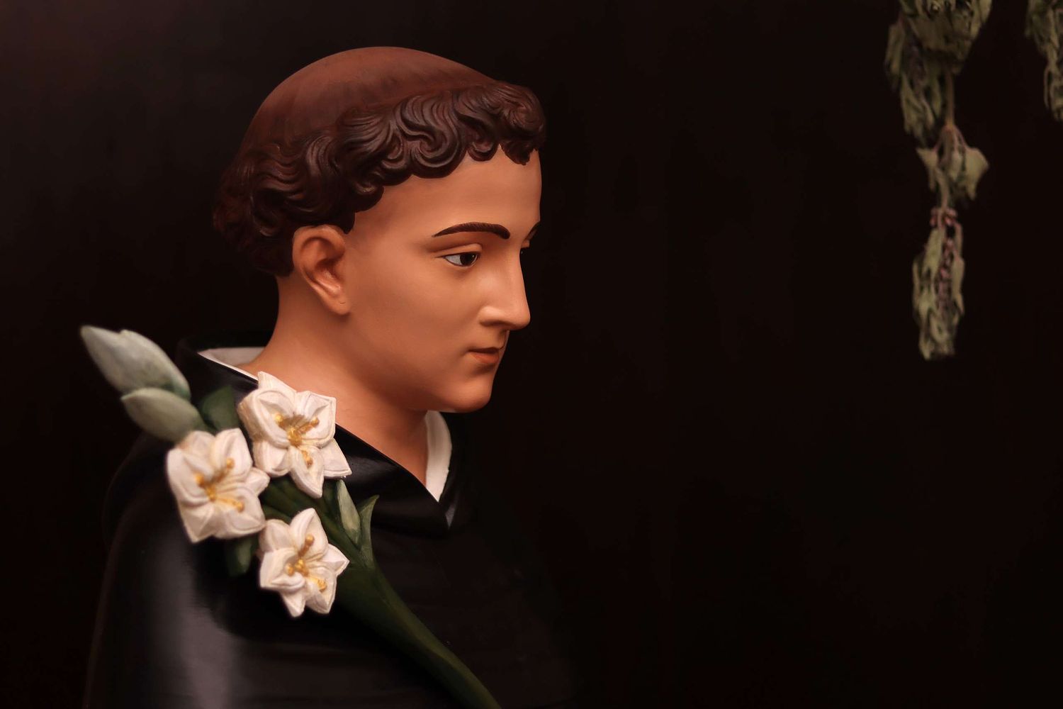 Restored statue of St. Dominic from the side, with his new lilies.