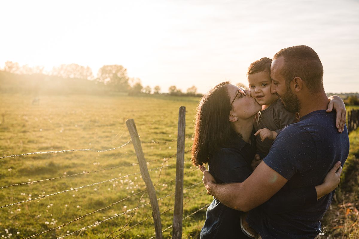 Moment tendre d'une famille au coucher de soleil captur&eacute; par un photographe famille &agrave; Lyon