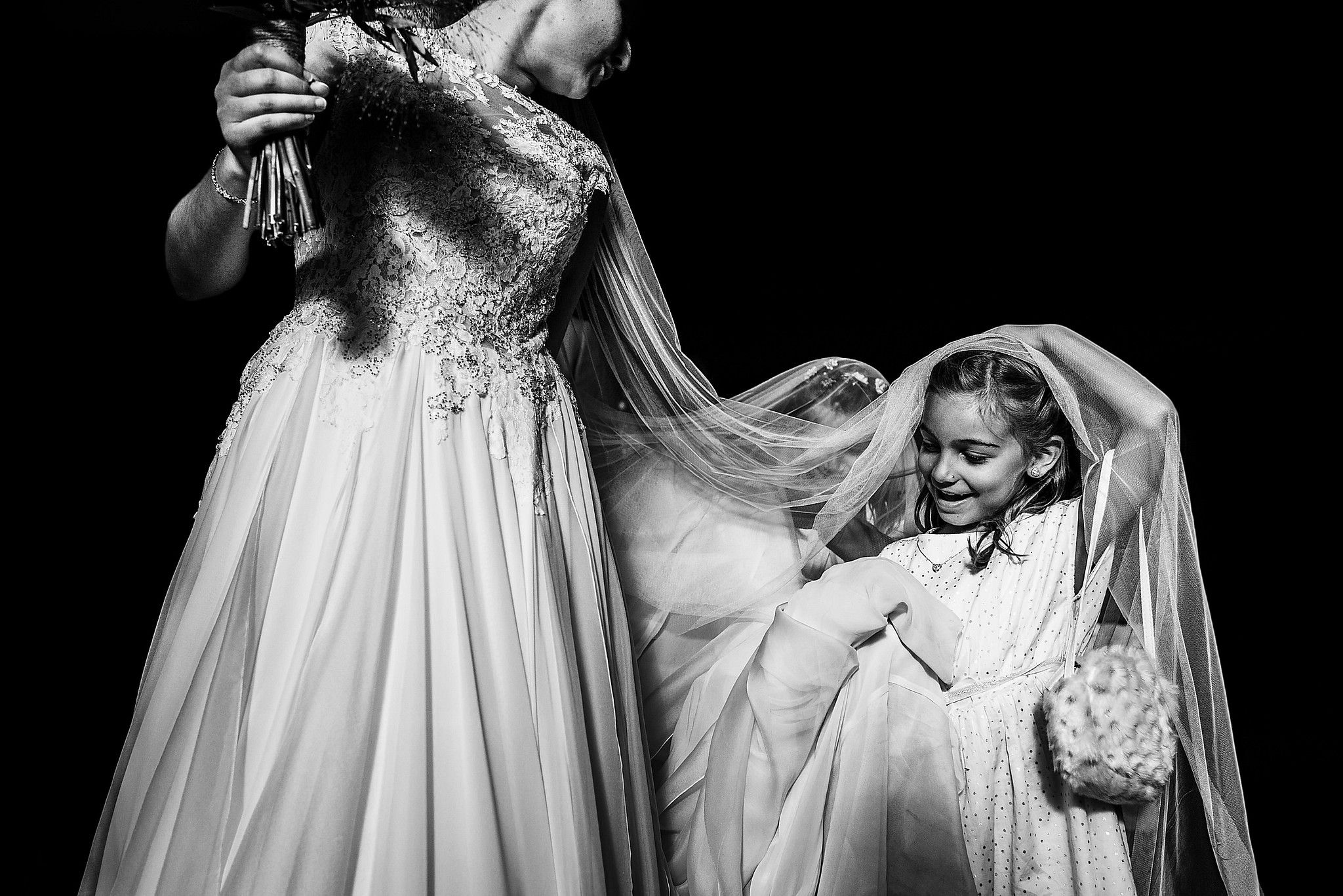 Enfants qui rigolent et qui jouent dans la robe de la mari&eacute;e &agrave; la sortie de l'&eacute;glise captur&eacute; par S&eacute;bastien CLAVEL photographe de Mariage &agrave; Lyon et Gen&egrave;ve
