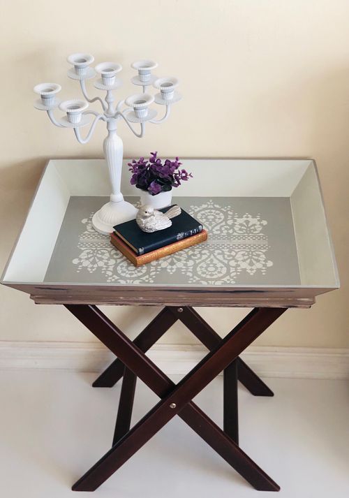 Wooden table with decorative items such as books, a flower arrangement, and a candle