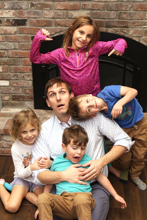 Father with his four children are shown in a hilarious pose