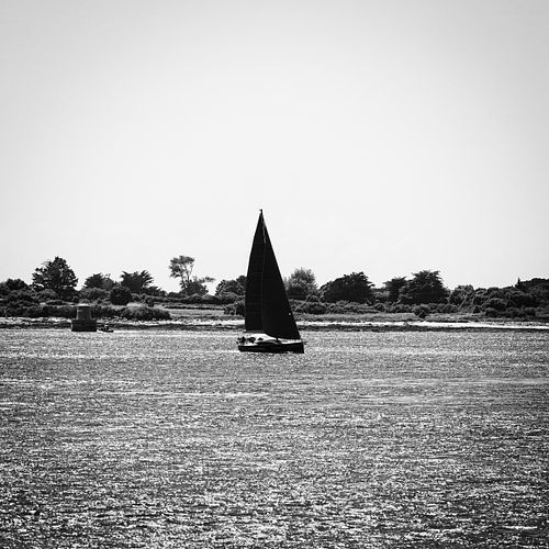Bateau noir sous ciel contrasté.