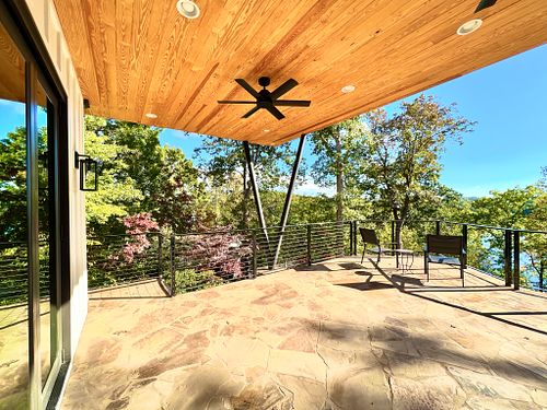 sunlit underdeck; wood ceiling, fans, stone patio