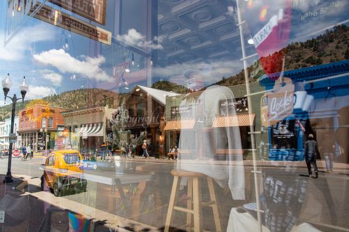 Idaho Springs Colorado lively main street yellow car mountain backdrop