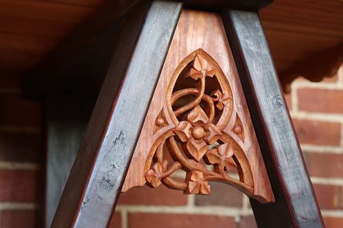 detail of a gothic carving in cherry on a medieval trestle table