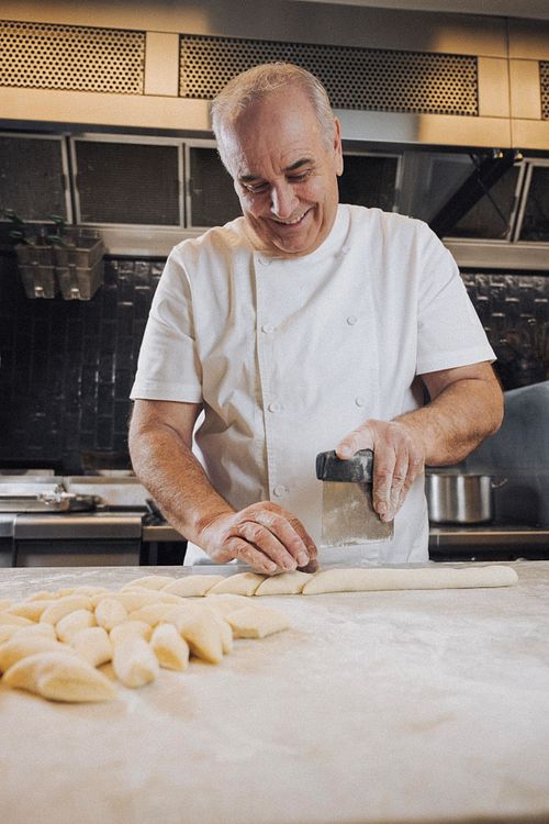 E'cco Bistro's Philip Johnson prepares his famous potato gnocchi. A low angle photo where he is slicing the gnocchi and stands in his restaurants kitchen.