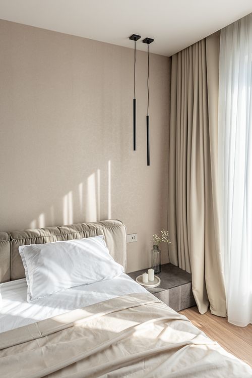 Bedroom illuminated by warm sunlight, highlighting minimalist design – Scala project