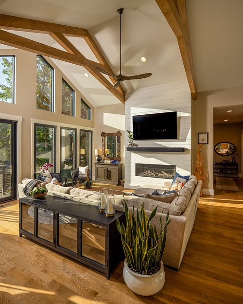 Overall view of seating area in living room with sunshine pouring in the windows