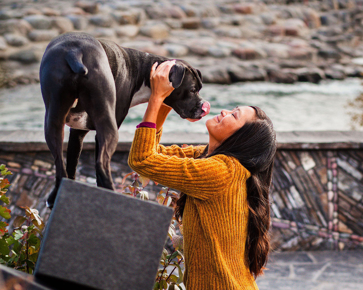 Dog and owner cuddling during outdoor pet photography session in Calgary at Pearce estates park.