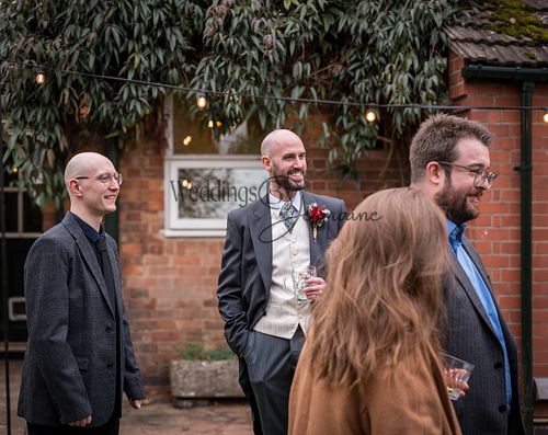 A group of friends gathered and chatting during the wedding reception, enjoying the celebration together, captured by Weddings By Jermaine.