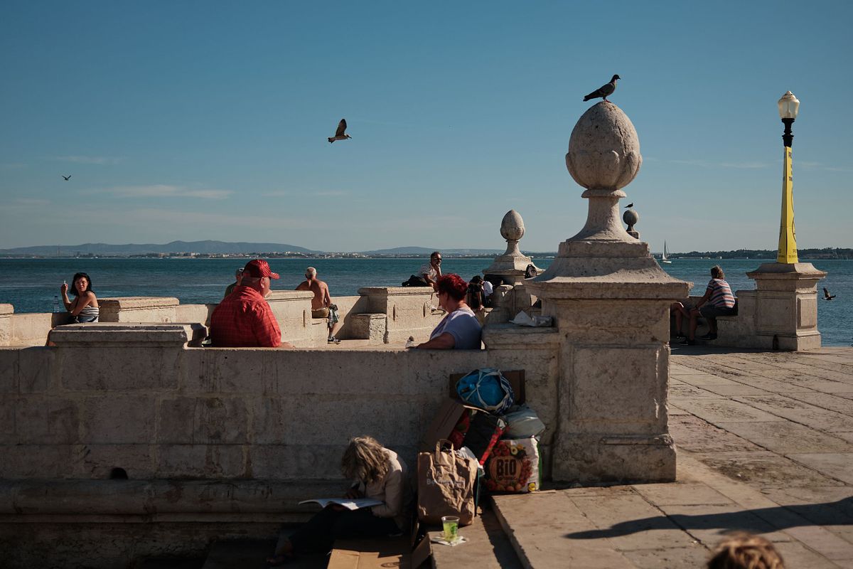 People relaxing by the waterfront in Lisbon on a summer afternoon, captured by photographer Sandeep Gajula