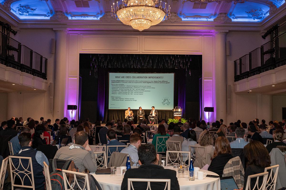 Corporate event photography capturing a leadership panel on stage before an engaged audience at a large-scale professional conference, highlighting executive dialogue, audience engagement, and collaborative discussion.