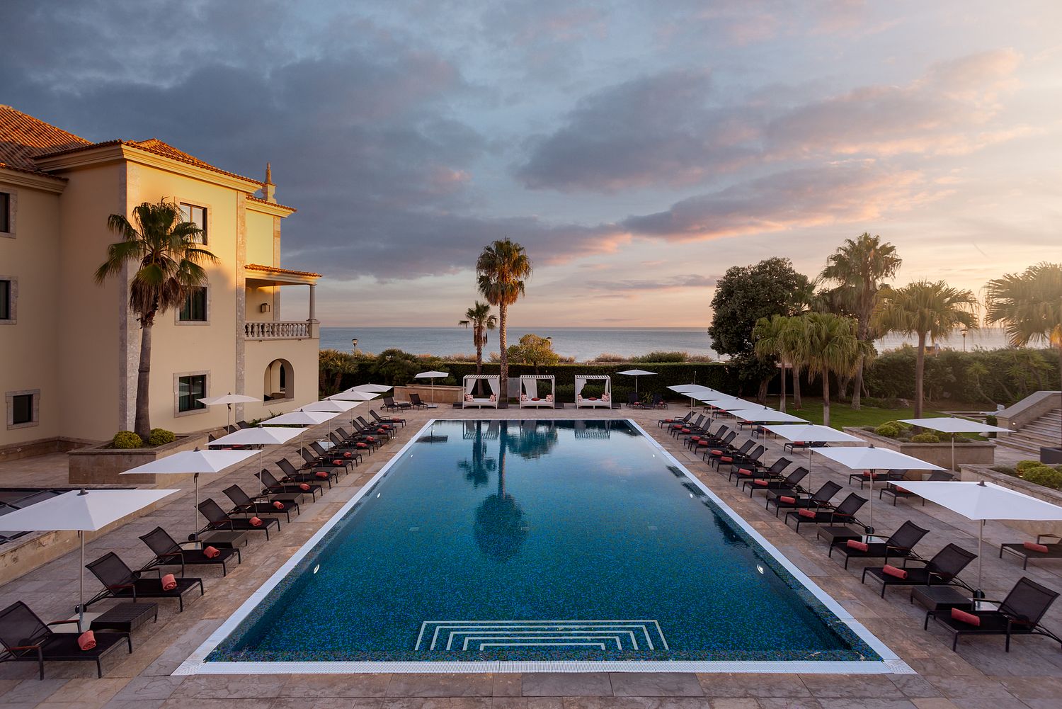 Piscina exterior do Grande Real Villa It&aacute;lia Hotel & Spa em Cascais, fotografada ao entardecer por Pedro Br&aacute;s Photography &mdash; fotografia profissional de hotelaria e resorts de luxo em Portugal.