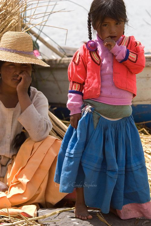 Mother Olympia and daughter Dora on the floating island of Apu Inti in Uros, Peru, showcasing their life and culture on Lake Titicaca