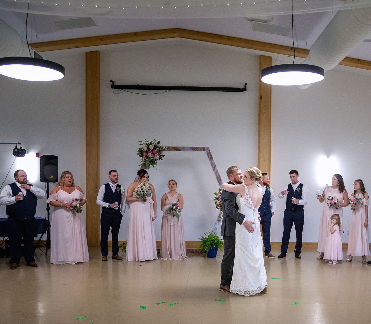 first dance surrounded by bridal party, with bridal party cheering and celebrating the couple