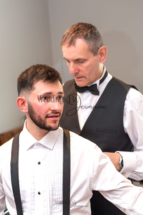 Wedding by Jermaine – father of the groom helping adjust the groom's shirt before the wedding