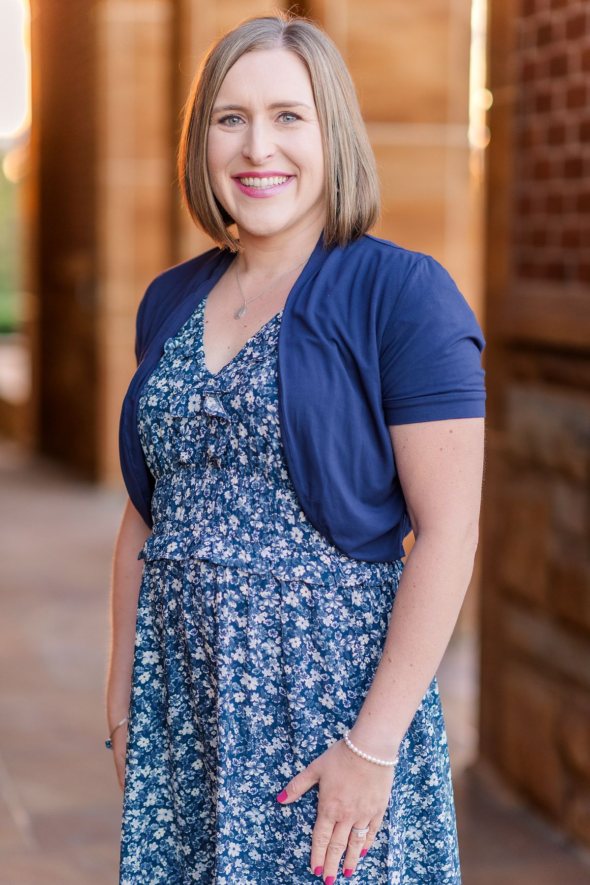 Beautiful smiling mother in Wexford Saints John & Paul arches golden hour light with a Cranberry Township, PA newborn photographer