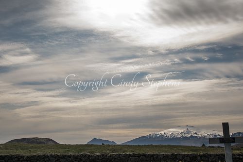 Grave marker with snow-covered mountains in the distance