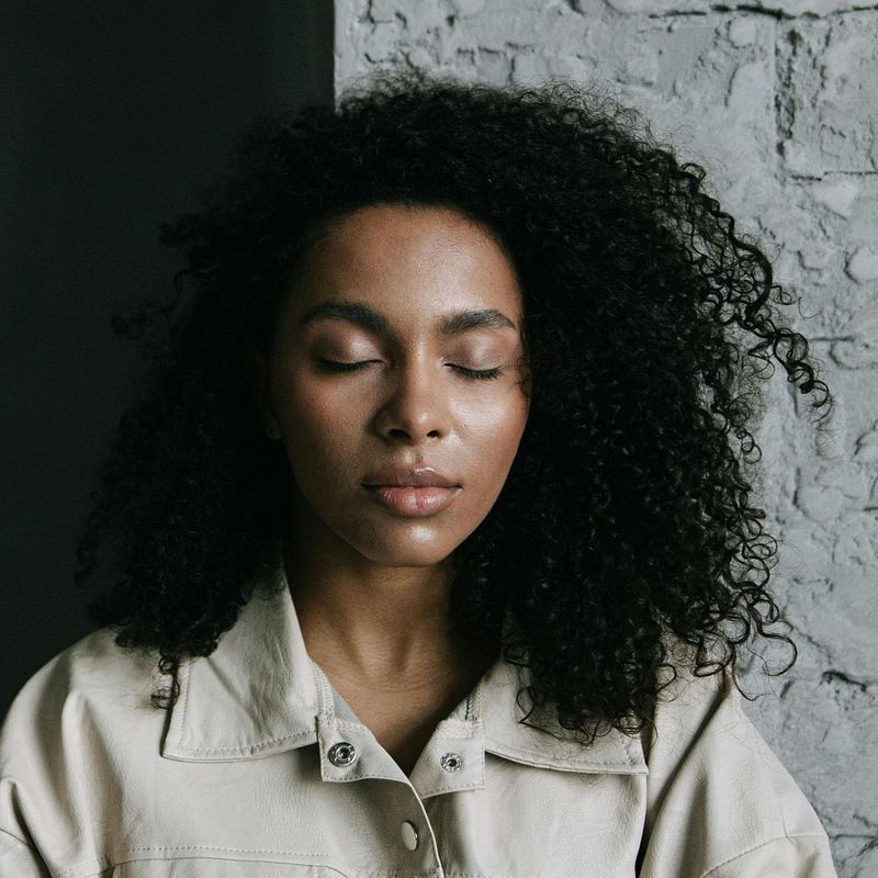 a peaceful looking middle aged woman with her eyes closed