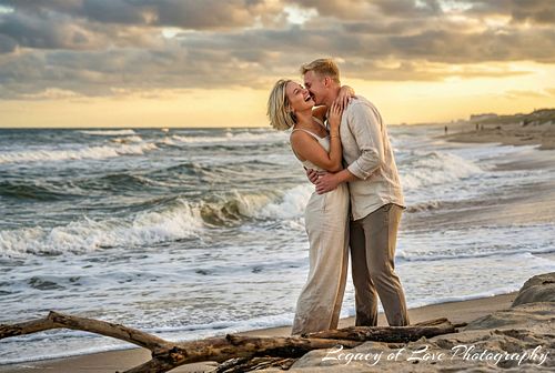Couple kissing on a St. Augustine beach after a surprise proposal at sunset by Legacy of Love Photography.