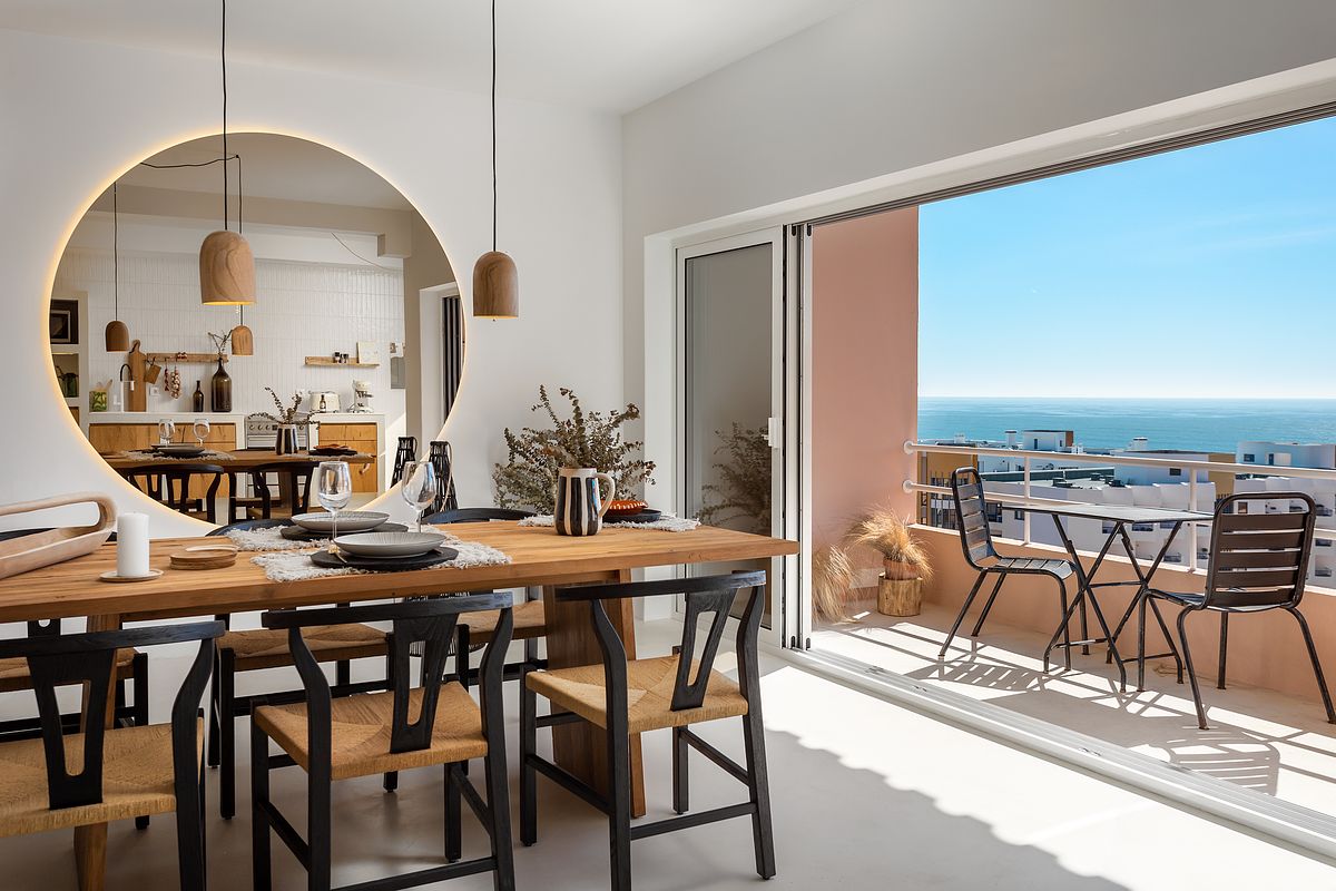 Sala de estar de apartamento T2 na Guia em Cascais com liga&ccedil;&atilde;o visual &agrave; varanda e vista mar