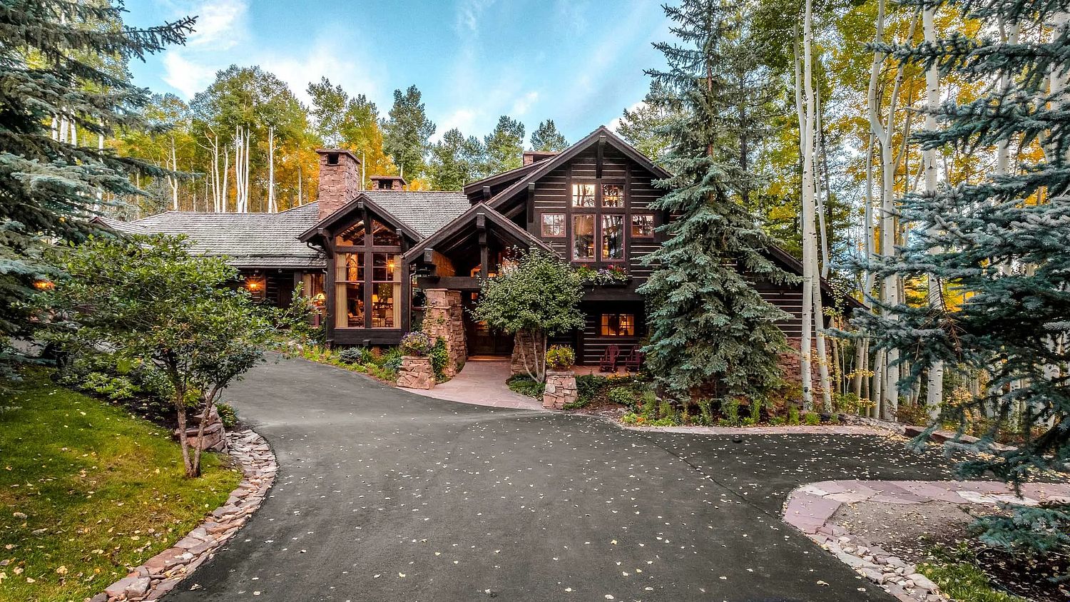 Modern rustic modern mountain retreat and luxury log home architecture in a wooden forest setting.