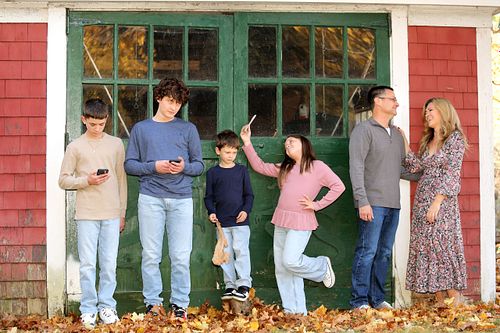 Large family poses with kids on cell phones