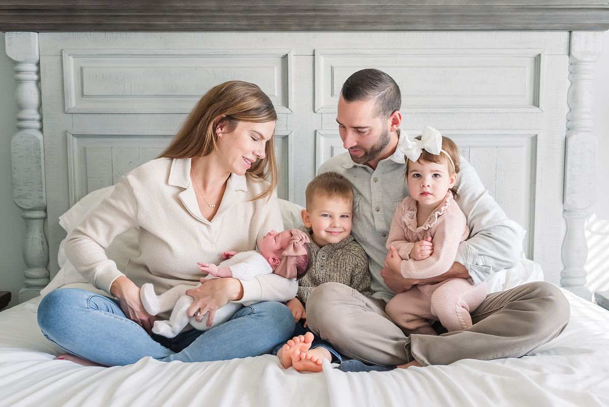 husband and wife with their three children, adoring each other with cranberry township, pa newborn photographer