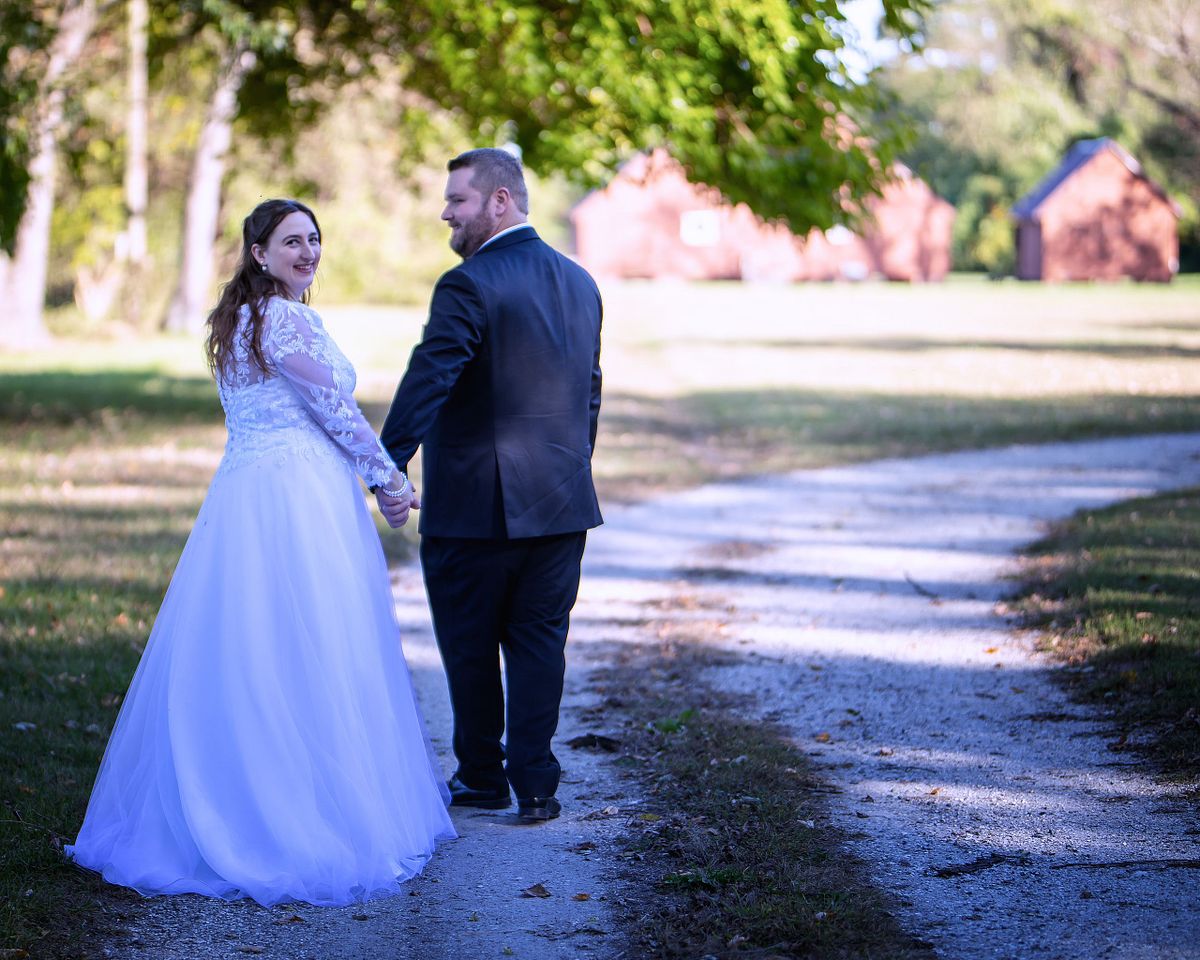a couple walking on the historic pathway at ross mansion after the ceremony during golden hour