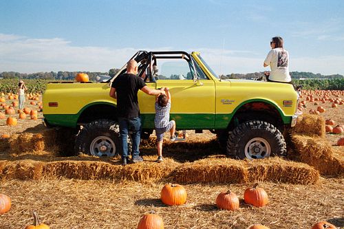 35mm film photo of family playing on a vintage truck
