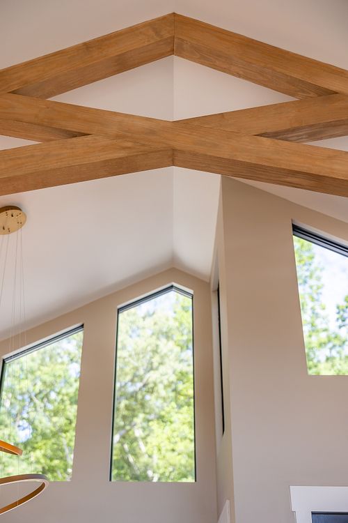 Custom profile Trapezoid window aligned with the vaulted ceiling and wood trusses