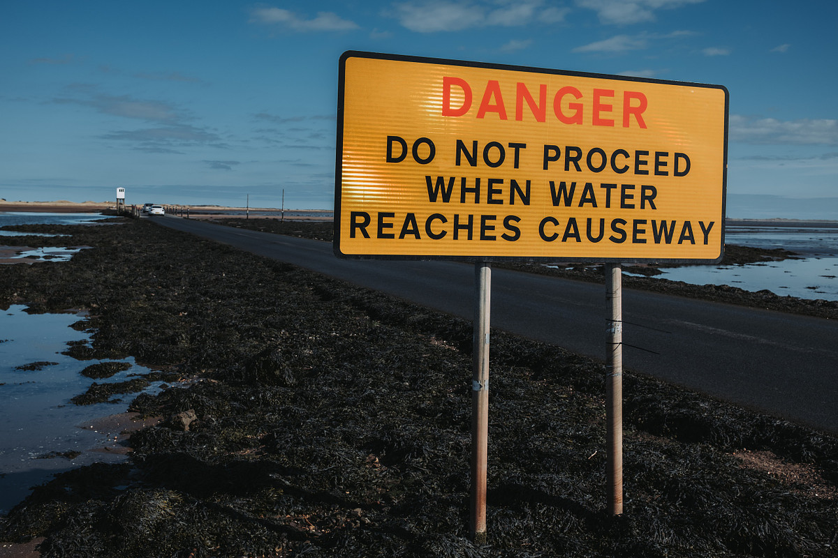 warning sign with sea either side