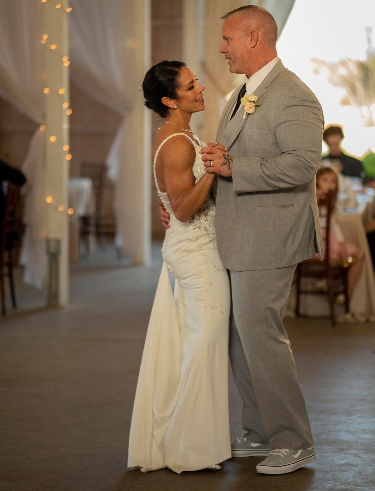 newly weds dancing first dance inside kylan barn, the both look happy and are smiling at each other