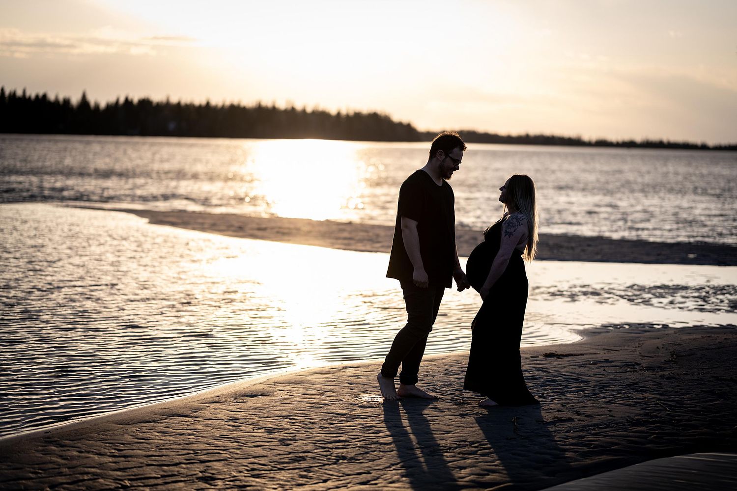 Silhouette of expecting couple at the beach during sunset.