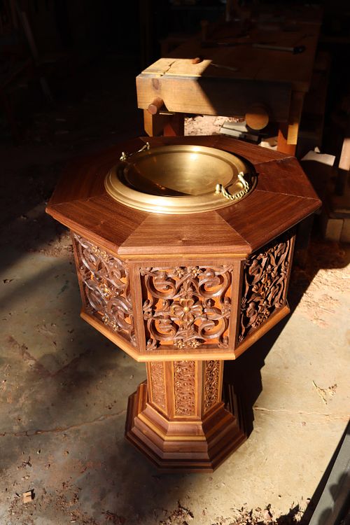 baptismal font showing the top and antique bowl along with the carvings