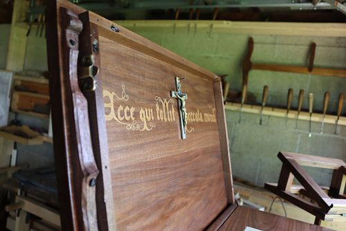 Reredos for the portable altar showing the crucifix and the gold lettered text the priest requested