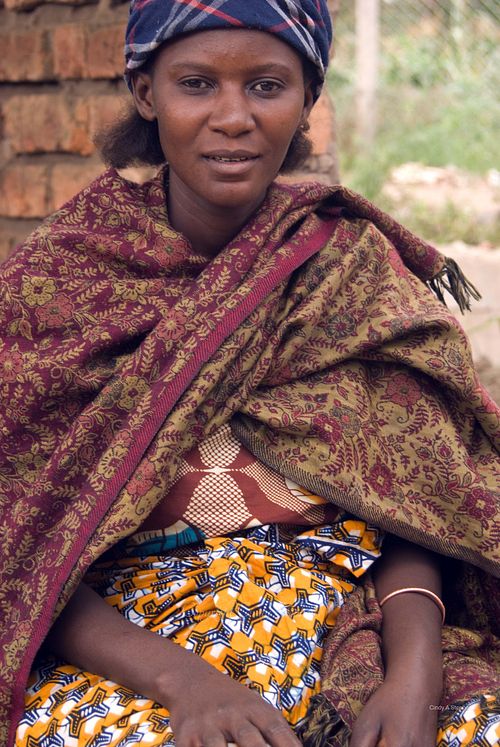 Paulina, dressed in vibrant traditional clothing, sitting in the market in Arusha, Tanzania, showcasing the rich cultural heritage.