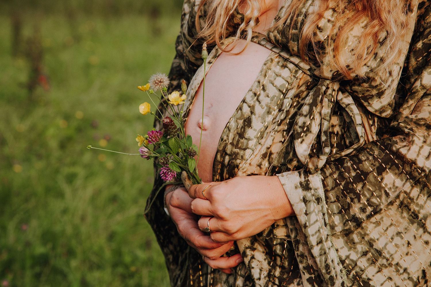 Schwangere Frau mit Blumenstrau&szlig; bei einem nat&uuml;rlichen Babybauchshooting im Park in K&ouml;ln.